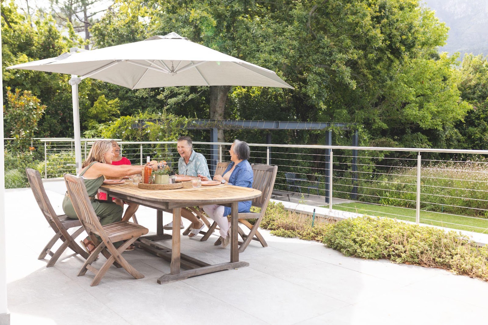Senior friends enjoying meal outdoors, chatting happily