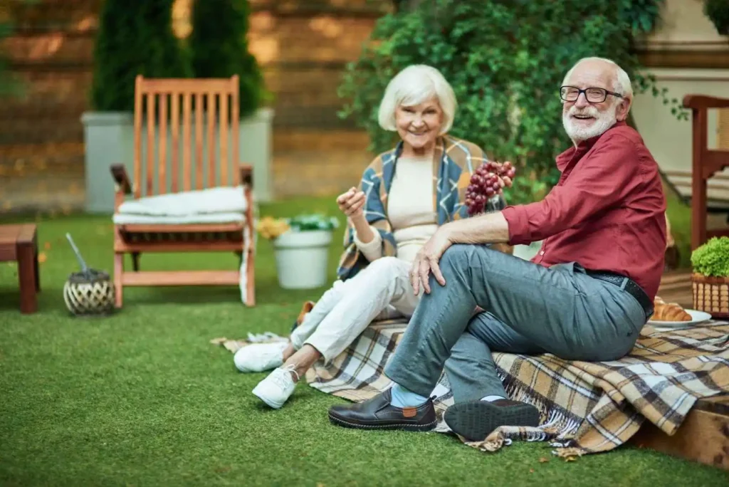 Elderly couple happily spending time on lawn  