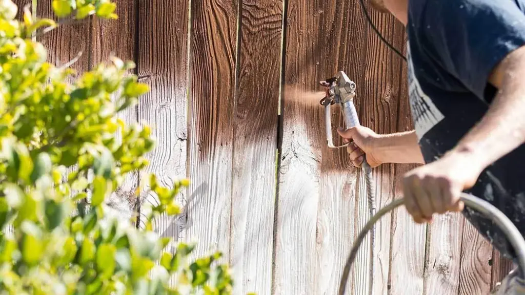 Handyman stains wooden deck 